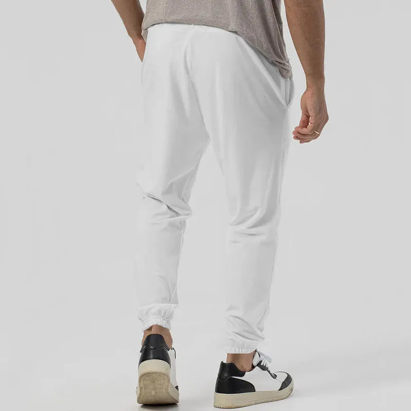 Men's grey cotton blend casual track sweatpants with a tapered leg on a plain background.
