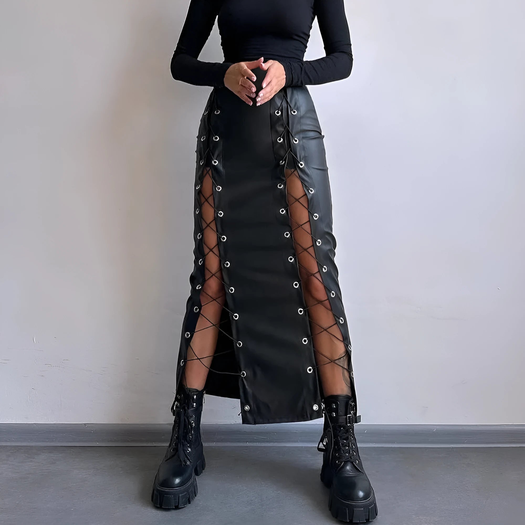 Women's black PU pencil skirt with slit and lacing detail, standing pose