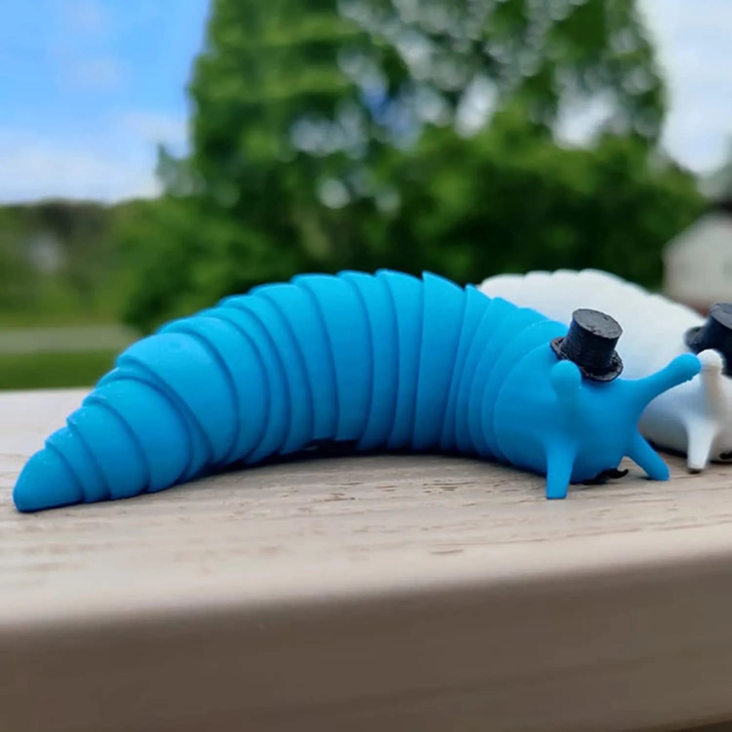 Decompression fidget toy simulation slug in blue plastic, 19 cm long, on a white background