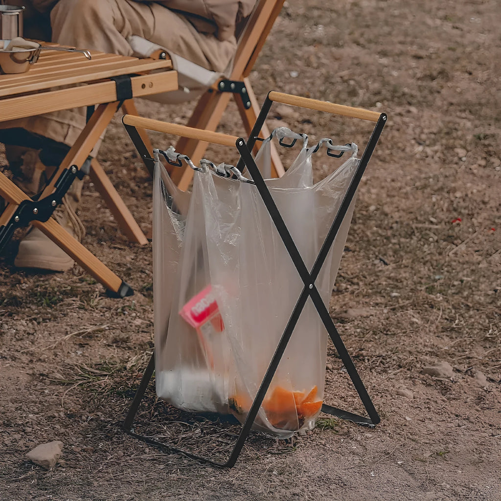 Folding outdoor rubbish rack with iron frame and wooden handle, shown in black colour.