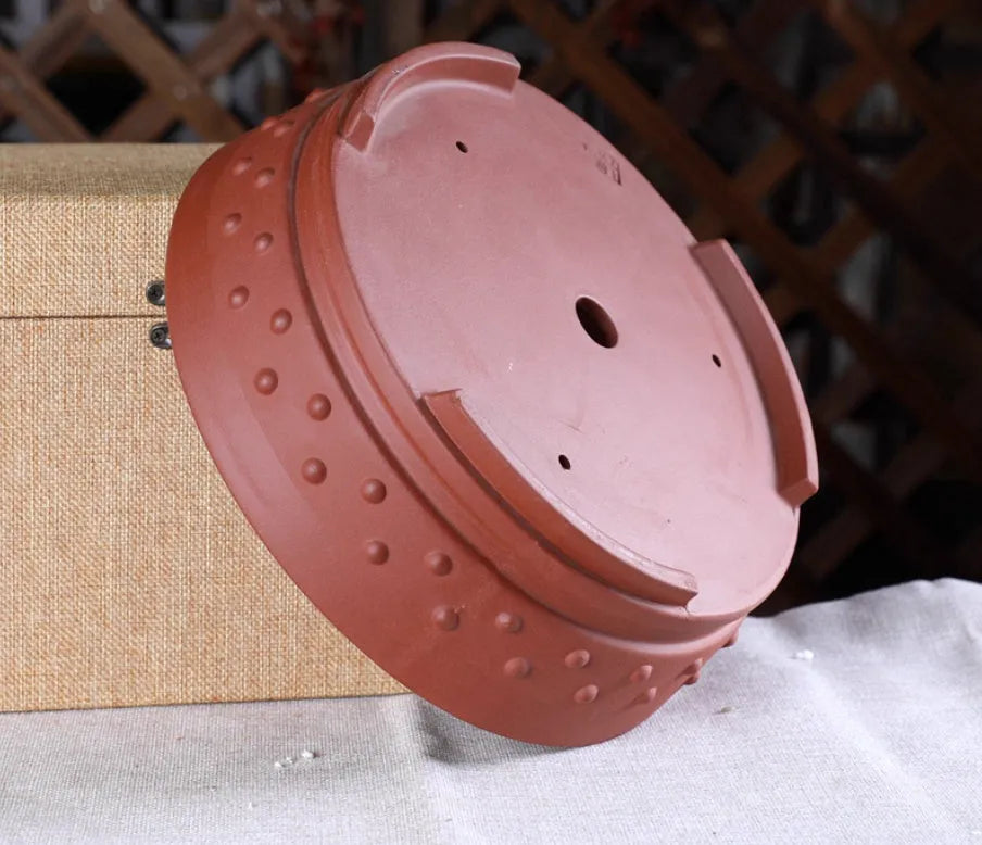Chinese style indoor tabletop drum nail purple clay ceramic flowerpot with breathable design in purple clay colour on a wooden surface