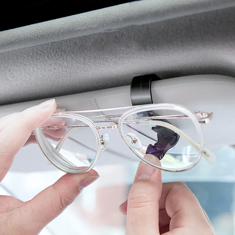 Black plastic clip for car sunshade to hold sunglasses and tickets.