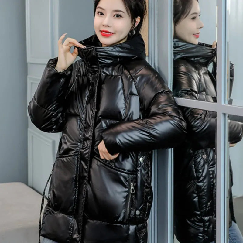 Green loose-fit hooded women's winter jacket on a hanger, showing long sleeves.