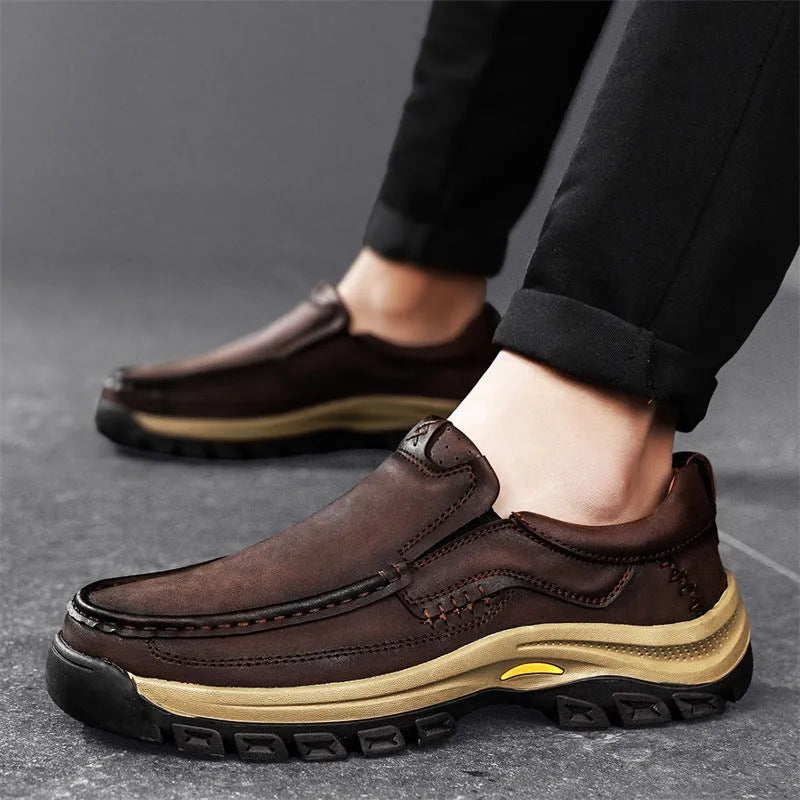 Men's black leather shoes with thick rubber soles and round toe design showing visible sewing thread construction