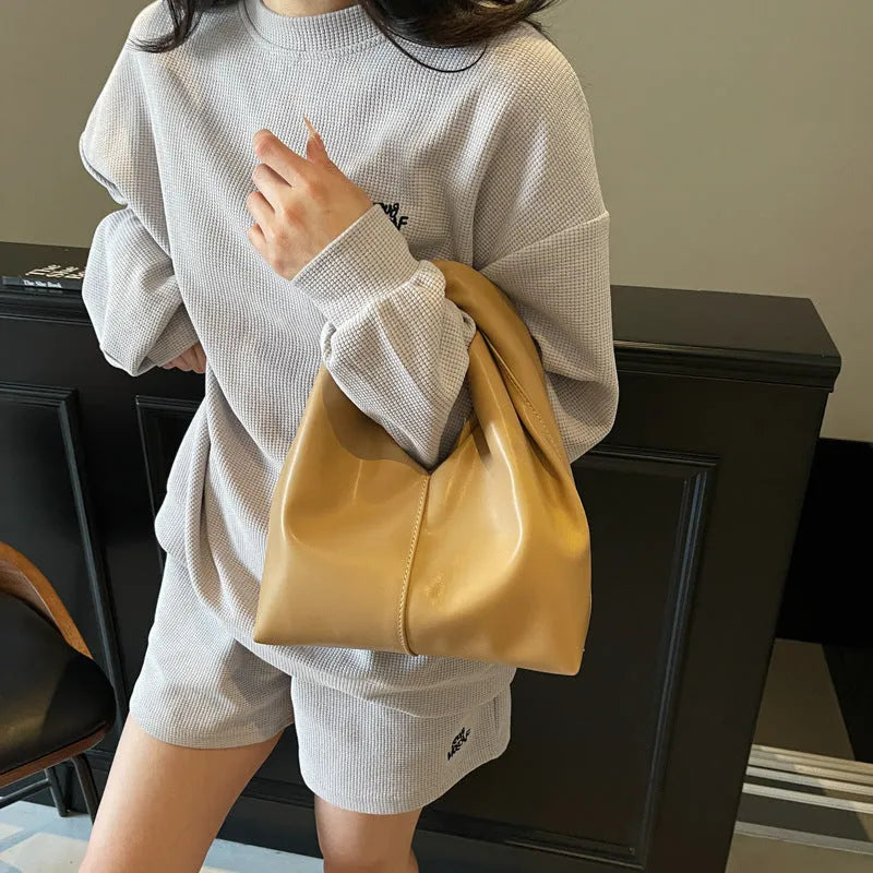 Women's casual dumpling-shaped PU leather handbag in multiple colours with internal organiser pockets.