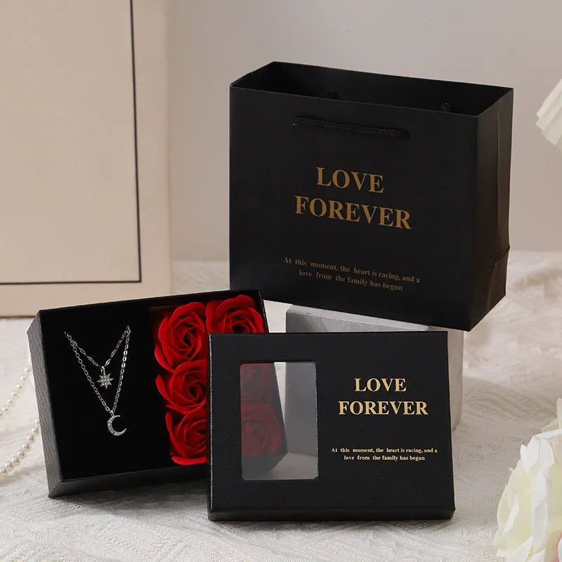 Six red soap flowers arranged in a black gift box with a matching handbag, a Valentine's Day gift set.