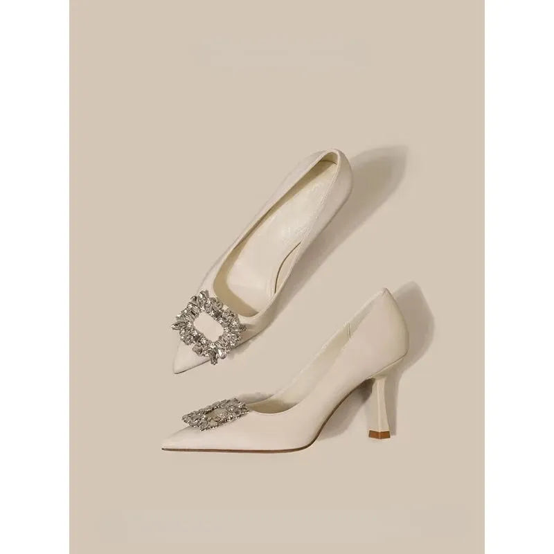 Women's pointed toe stiletto high heels in beige and black, showing low-cut design and thin heel.