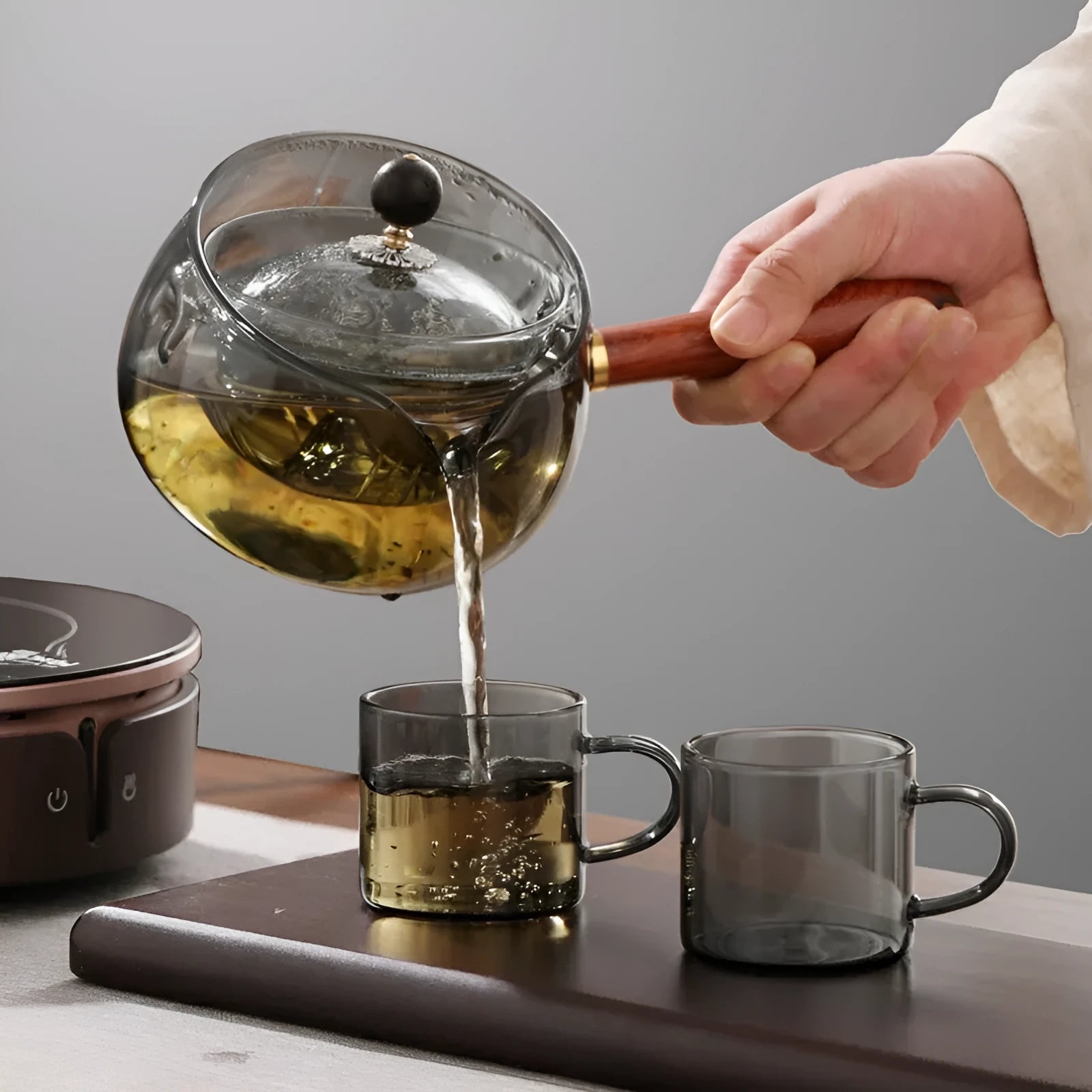 Semi-automatic rotary glass teapot with wooden handle and infuser, in grey and transparent colour options.