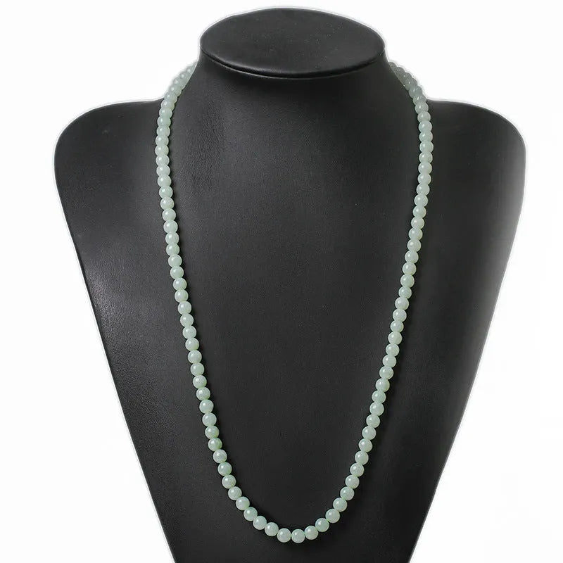 Natural white-green jade bead necklace with adjustable chain and 6.5mm round beads on grey background