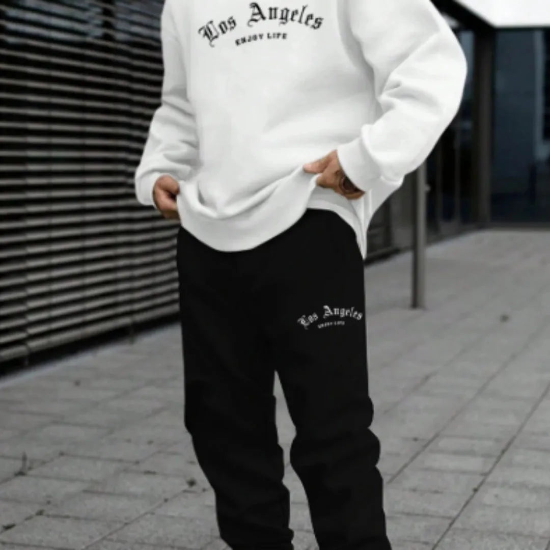 Man wearing a grey letter-print hoodie and matching joggers from a winter sports set.