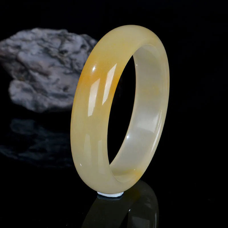 A polished natural light jade bracelet in a traditional Chinese style for women.