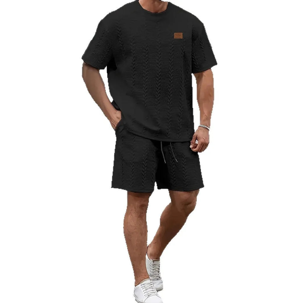 Men's black two-piece sports set with short sleeve T-shirt and matching shorts featuring patch design