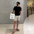 Men's loose straight casual shorts in black, white, and khaki solid colours made from polyester fabric
