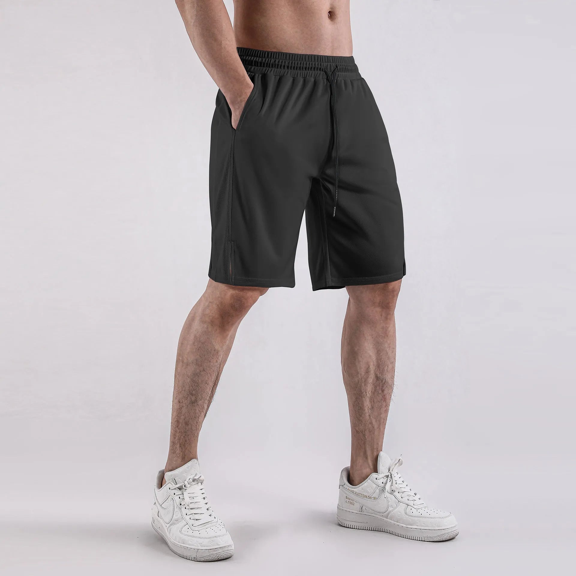 Man wearing black loose-fit quick-dry mesh shorts with an elasticated waistband.