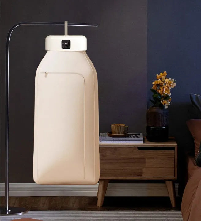 White cylindrical laundry dryer with remote control on countertop showing compact 29cm height