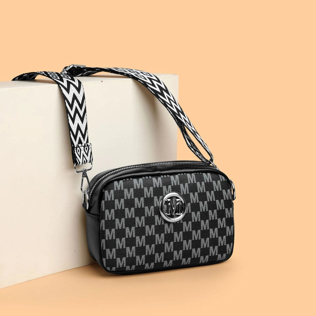 Crossbody bag with wide shoulder strap in black colour showing three-dimensional pocket construction