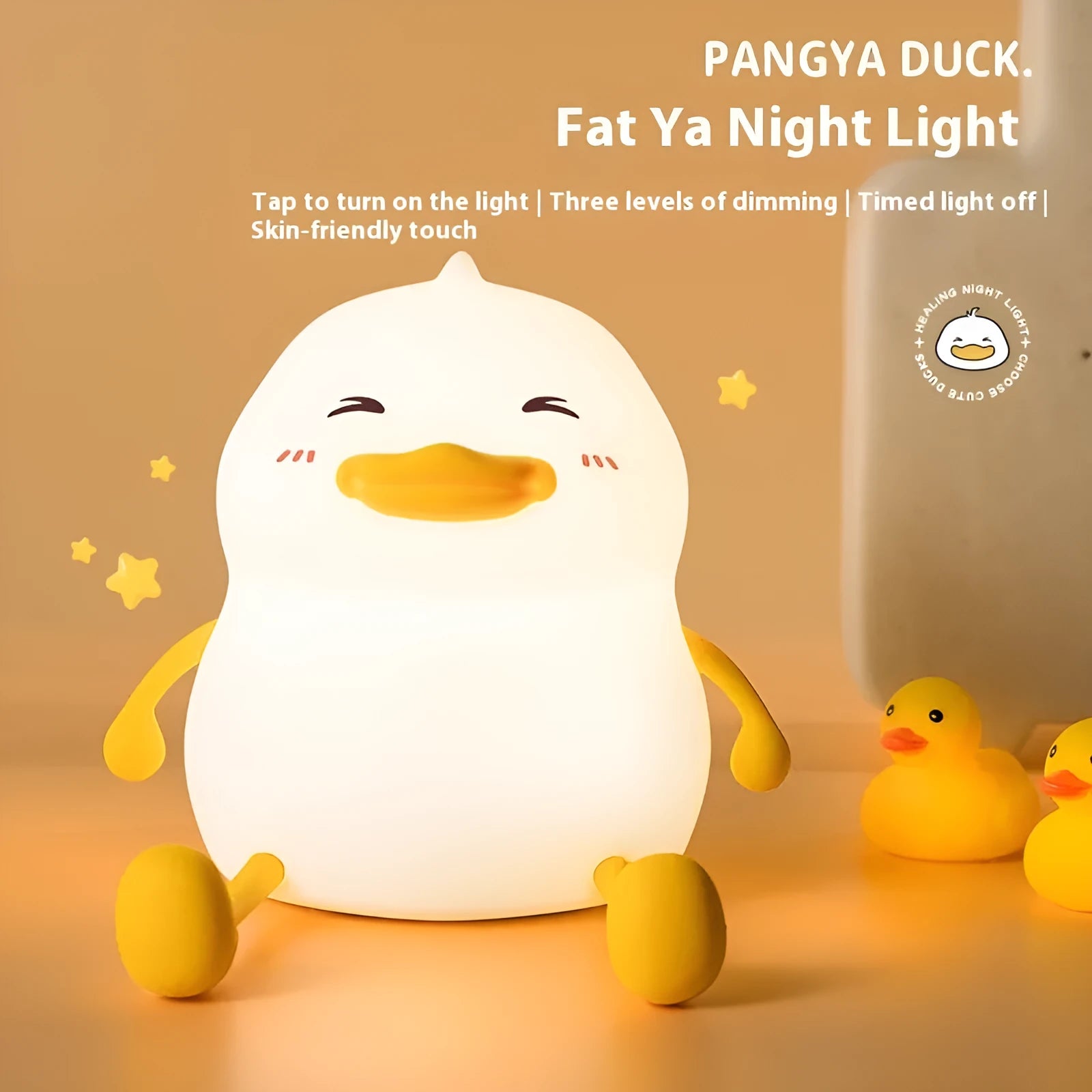 Chubby silicone pat night light on desk holding a mobile phone, showing soft glow.