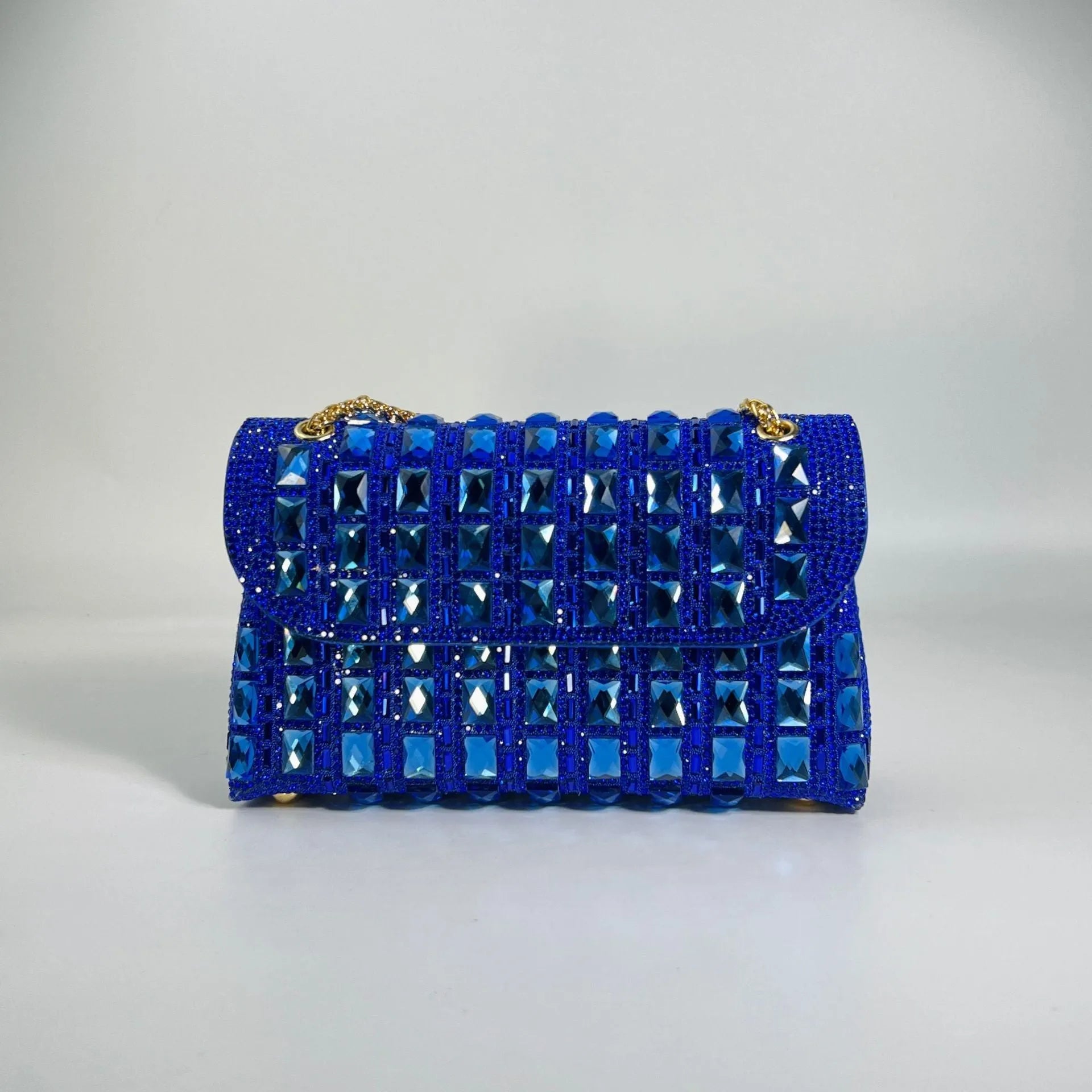 Silver rhinestone chain clutch bag with square shape and internal phone pocket on a table.