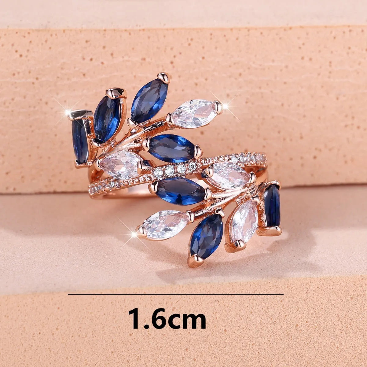 Adjustable copper leaf-shaped ring with zircon stone accents on a hand.