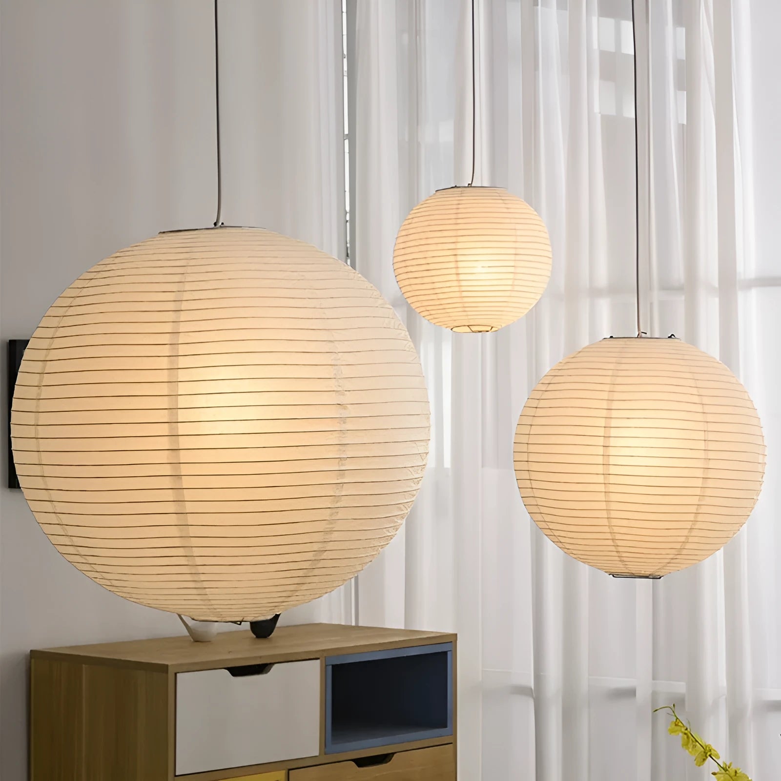 Modern simple paper pendant lamp with spherical or flat shade, shown in a bedroom or dining room setting.