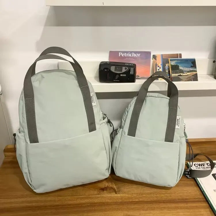 Solid colour nylon backpack with curved shoulder straps and lock details in multiple colour options