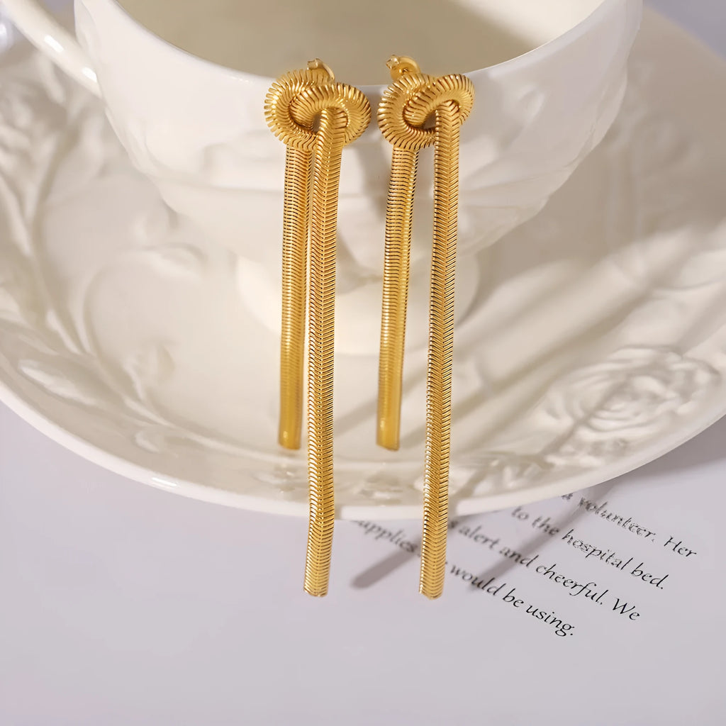 Gold plated titanium steel necklace with snake chain and knotted tassel pendant, shown with matching earrings.