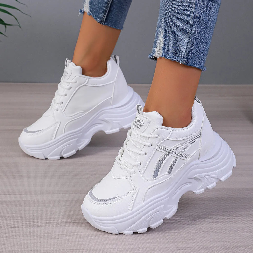 Women's platform wedge sneakers in black or white with mesh lining, rubber sole, front lace-up, round toe, and sewing thread detail.