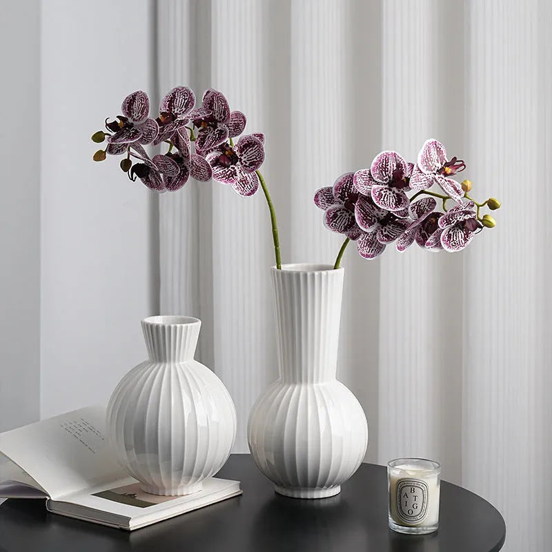 White ceramic vase with blue stripes in ball shape on wooden table