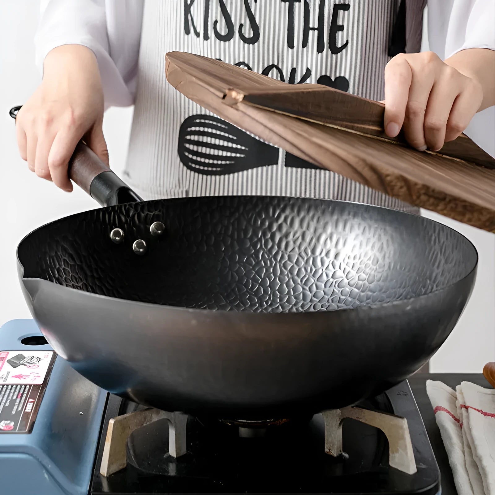 Black traditional iron wok pan with wooden handle and induction base