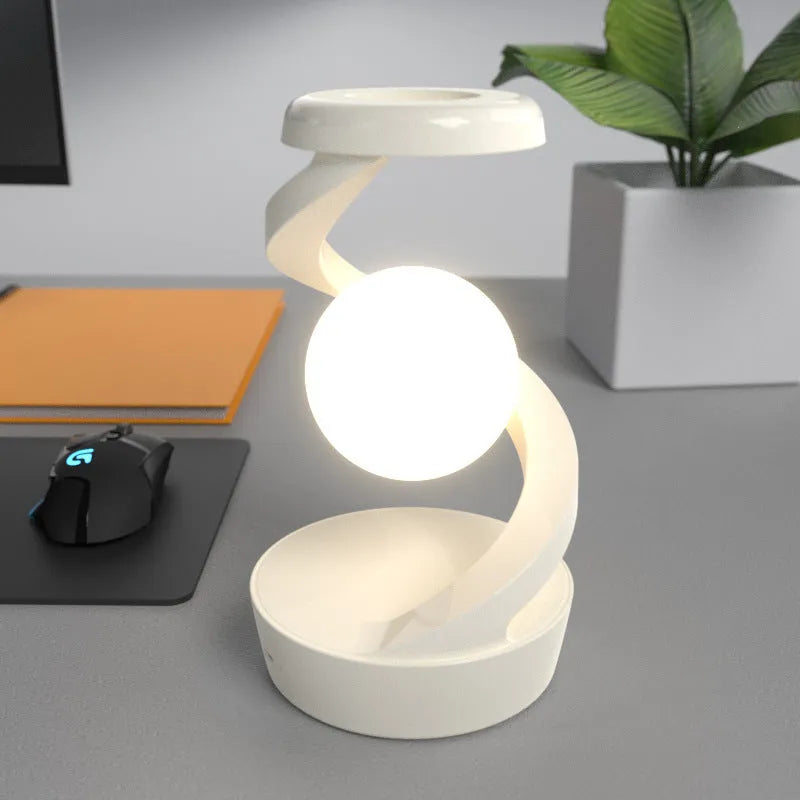 Rotating moon desk lamp with wireless charger in grey on a bedside table