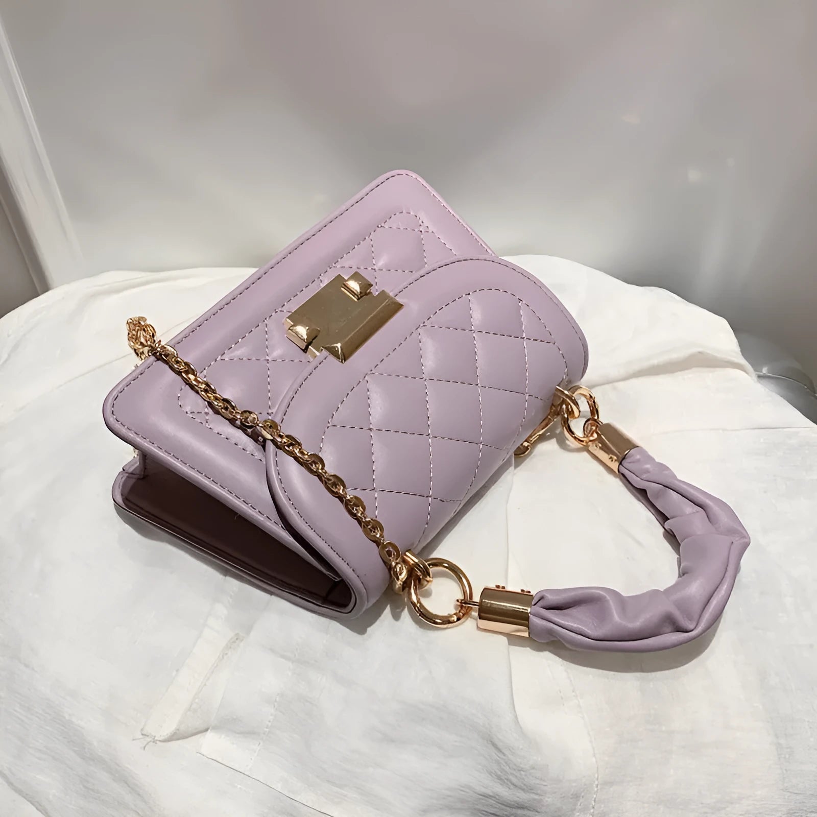 Purple rhombus-shaped small square ladies bag with chain-link shoulder strap on a white background
