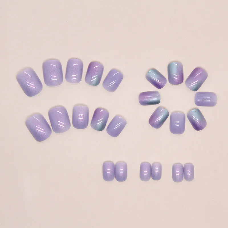 Short false nails with bright Aurora starry sky pattern and included glue tube.