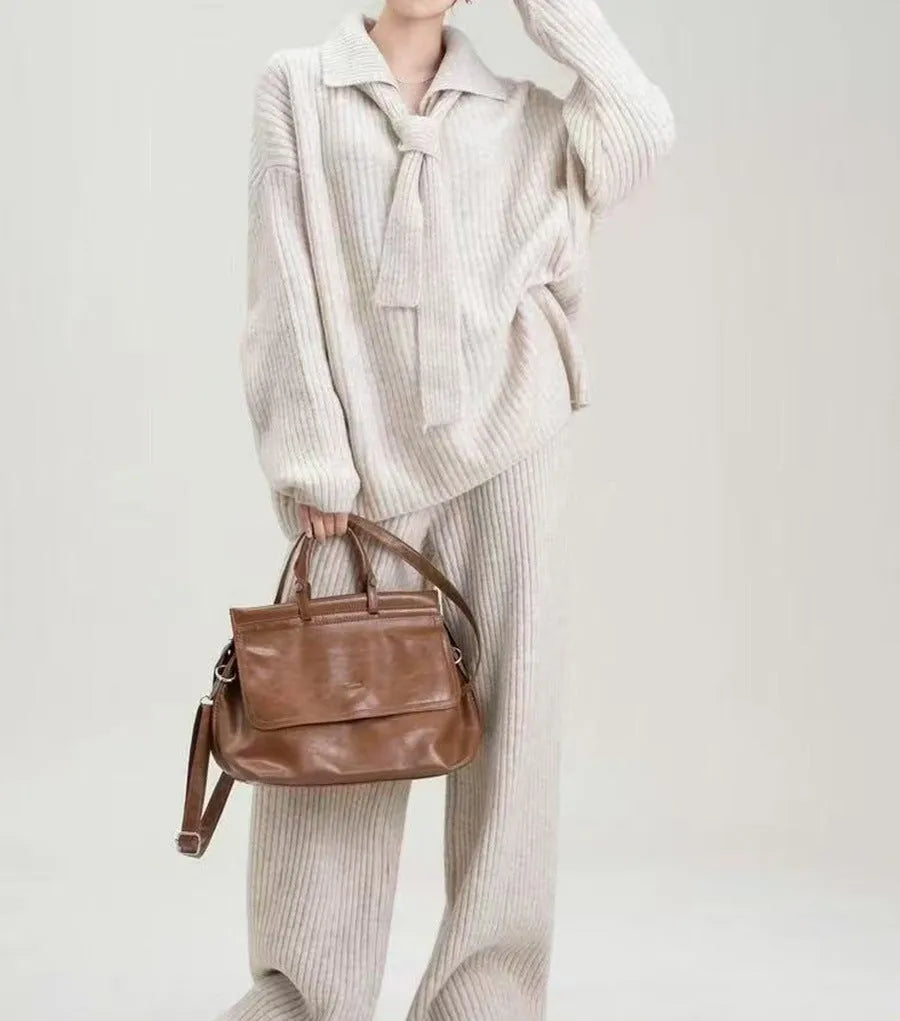 Woman wearing a beige acrylic knit sweater top and matching trousers from a casual two-piece set.