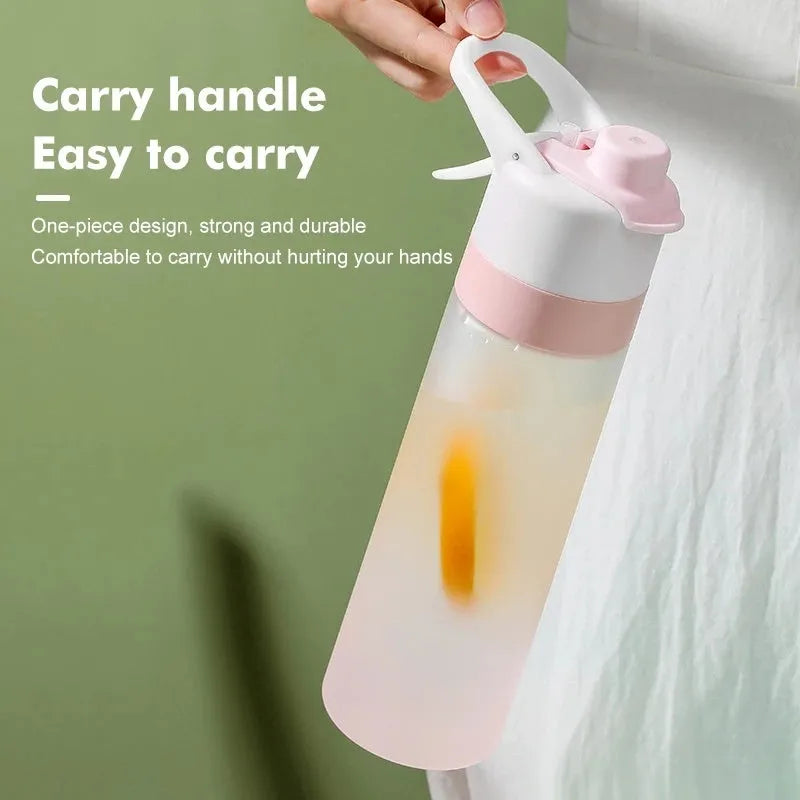 Large pink plastic spray water bottle with a handle strap and leakproof lid on a gym bag.