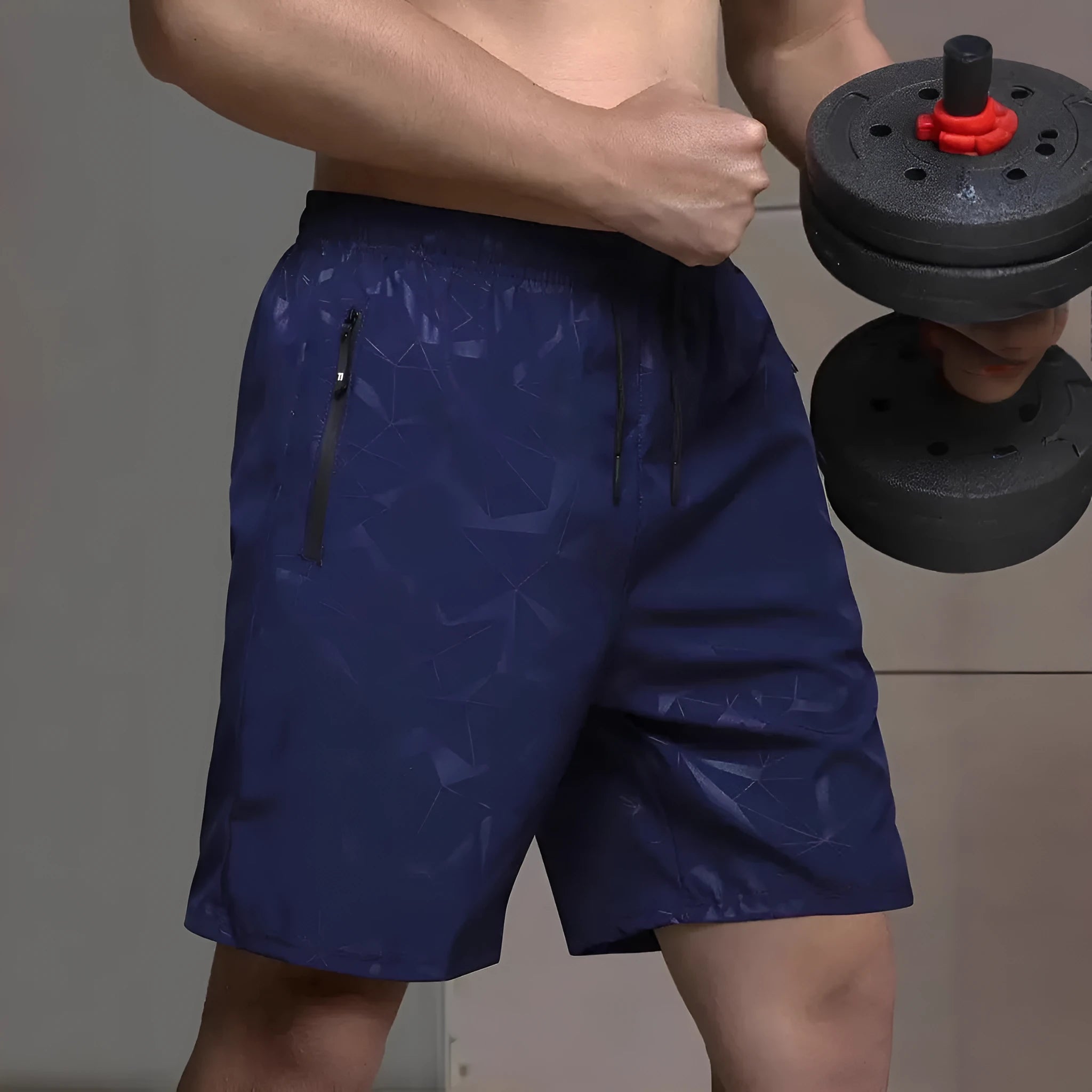 Man wearing loose grey printed polyester sports shorts on a beach.