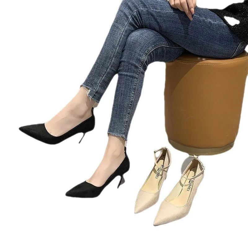 Women's black stiletto heel pump shoes with a buckle strap on the side.
