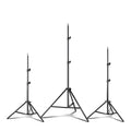 Black mobile phone tripod extended to 1.1m on a desk showing metal legs and phone mount