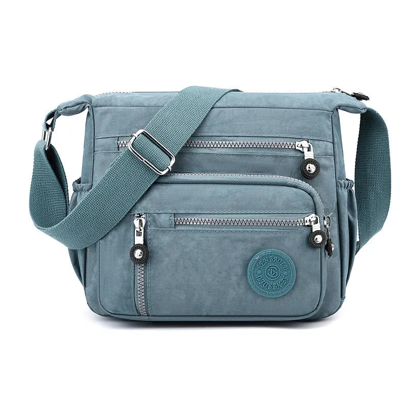 Soft grey nylon messenger bag with single shoulder strap showing square vertical shape