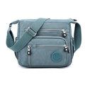 Soft grey nylon messenger bag with single shoulder strap showing square vertical shape