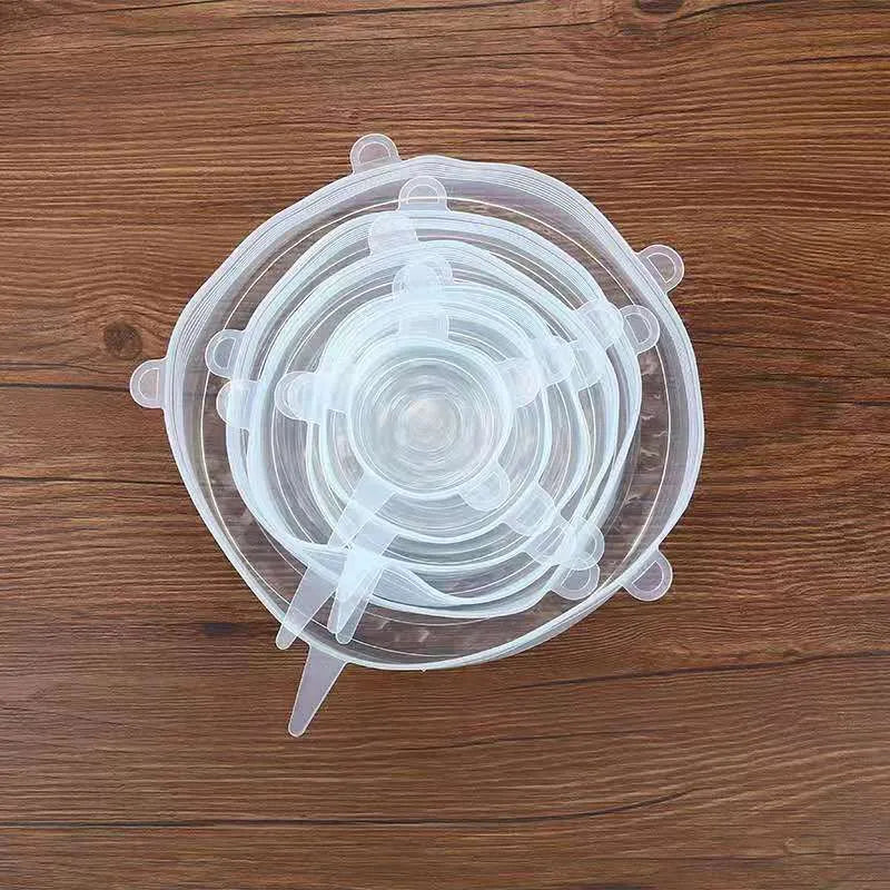 Set of six colourful silicone stretch food covers in different sizes on a kitchen counter.