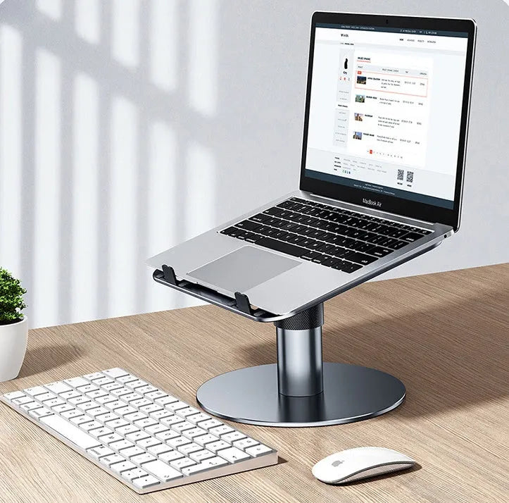 Silver adjustable aluminium alloy laptop stand on a car back seat, showing height adjustment and ventilation holes.