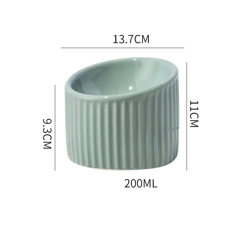 A dark green ceramic elevated cat bowl showing its raised height and round, whisker-friendly shape.