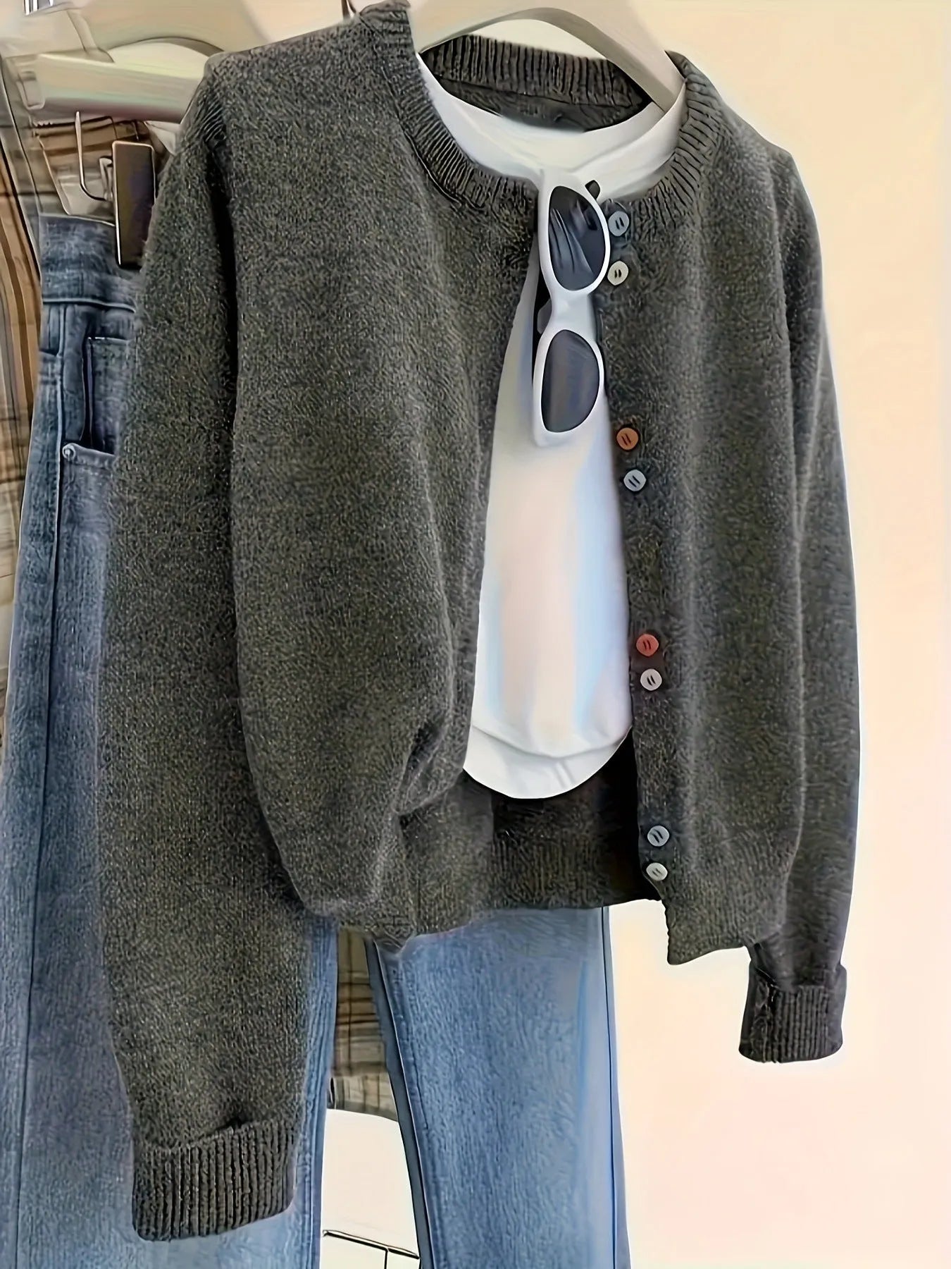Dark grey women's polyester cardigan sweater with buttons and long sleeves on a hanger.