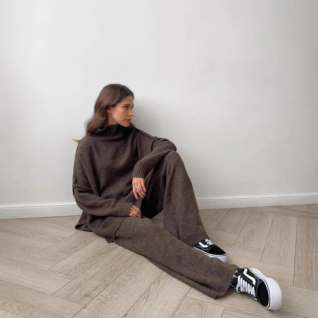 Women's dark grey acrylic knit sweater suit with side-slit top and matching trousers.