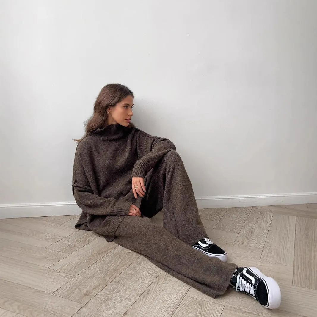 Women's dark grey acrylic knit sweater suit with side-slit top and matching trousers.