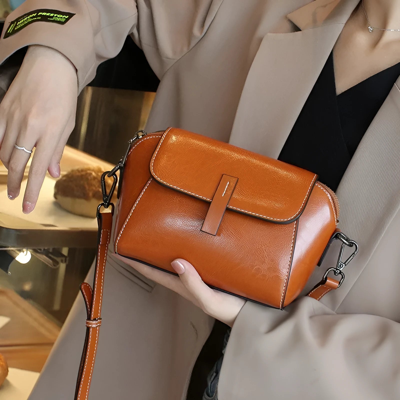 Women's brown oil-wax cowhide leather shell-shaped messenger bag with crossbody strap and visible sewing details