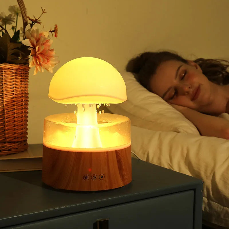 White cloud-shaped humidifier and aroma diffuser with LED lights and simulated raindrops.