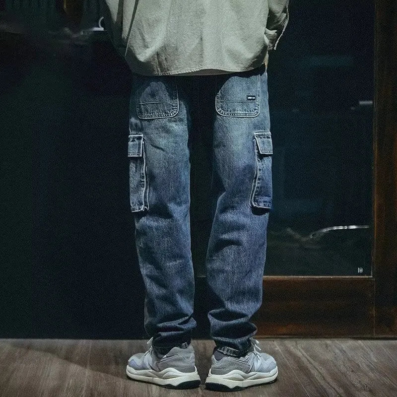 Man wearing blue loose straight-leg stretch denim trousers for a casual retro look.