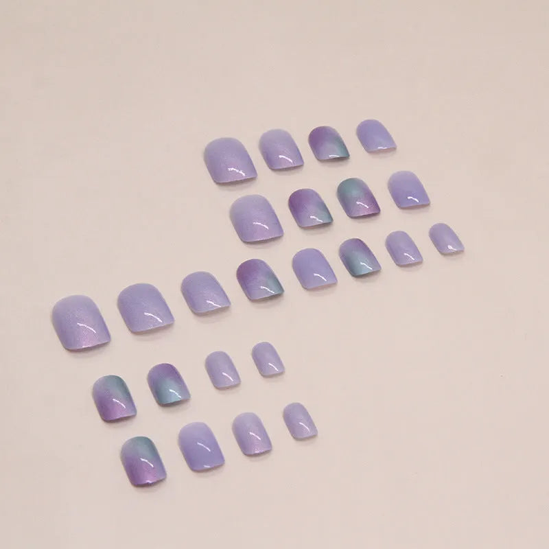 Short false nails with bright Aurora starry sky pattern and included glue tube.