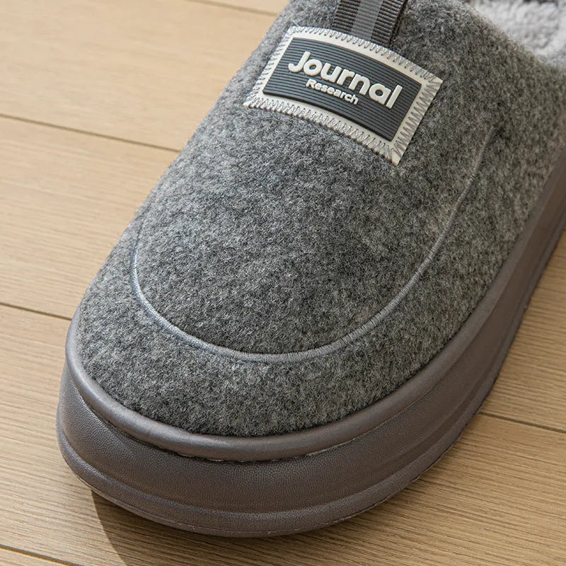 Men's brown suede slippers with a thickened sole on a wooden floor